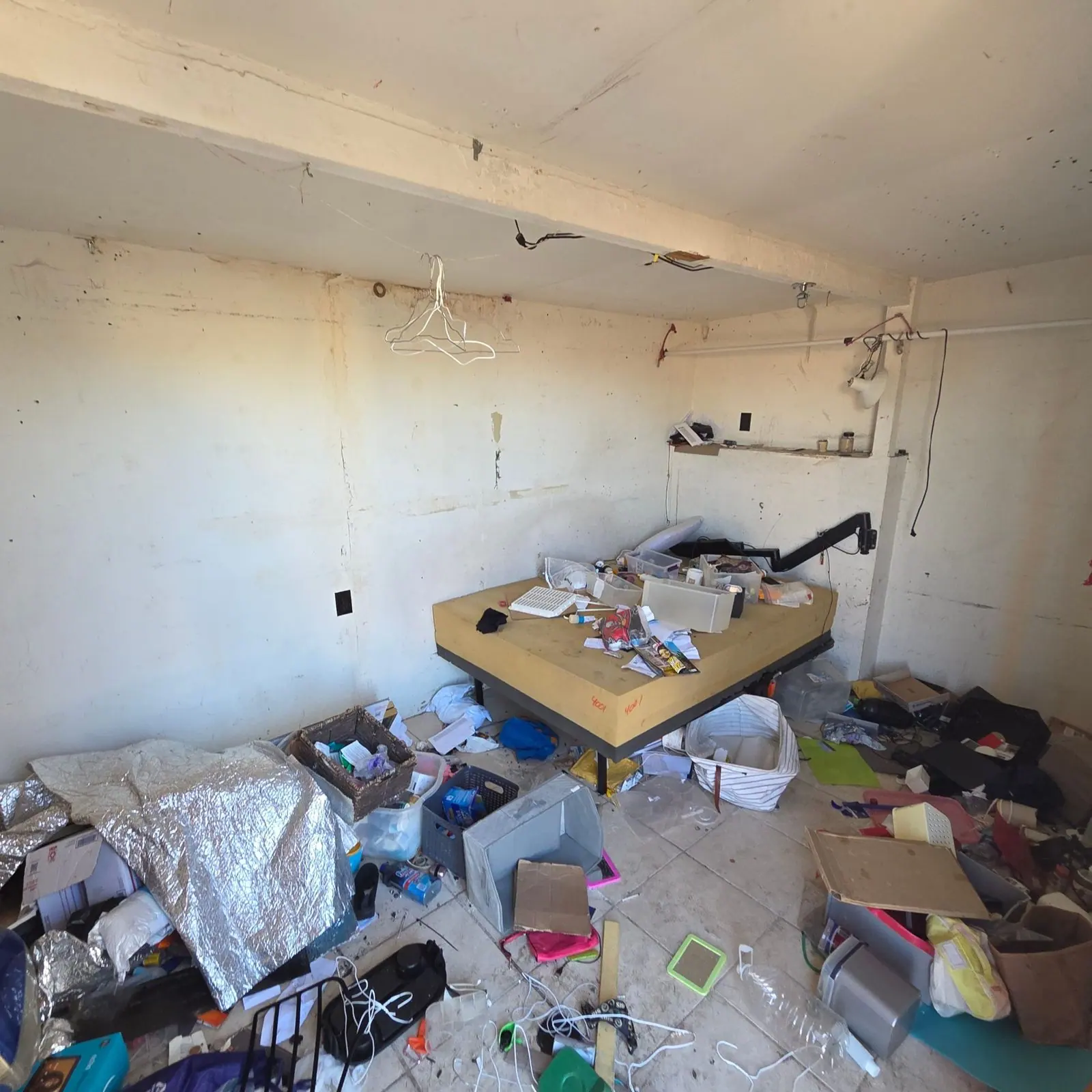 Cluttered room in a manufactured home near Cadence in Henderson with belongings, boxes and loose trash covering the floor before a hoarding cleanout