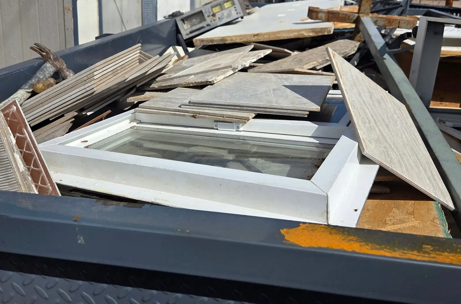 Henderson Junk Solutions trailer loaded with old tile, window frames, lumber and a cassette deck from a hoarding cleanout in Henderson, NV